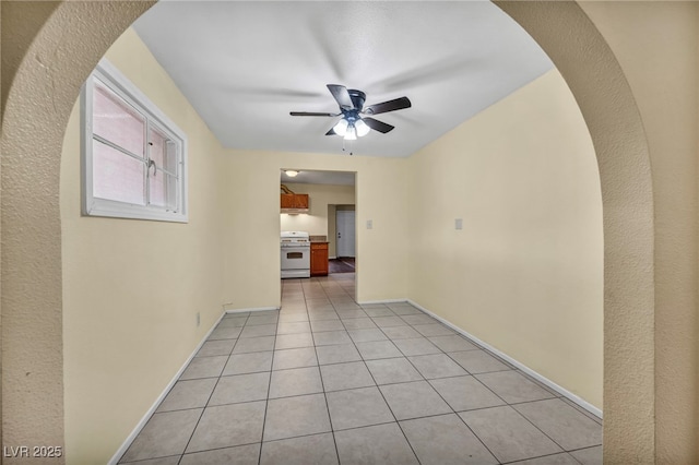 tiled spare room with ceiling fan