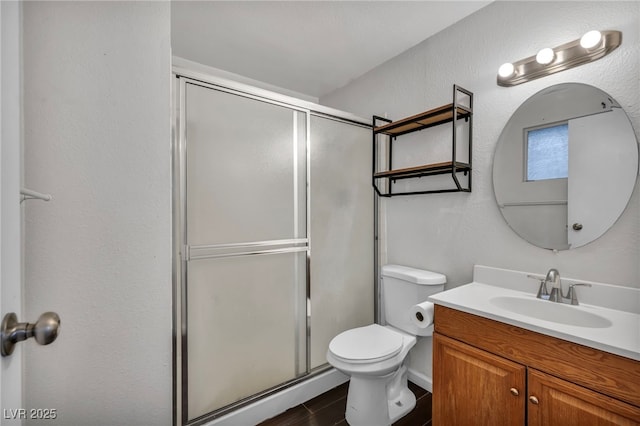 bathroom featuring toilet, vanity, and walk in shower