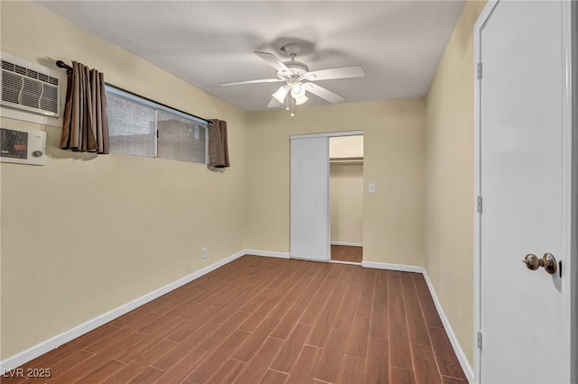 unfurnished bedroom featuring hardwood / wood-style flooring, ceiling fan, a wall mounted AC, and a closet