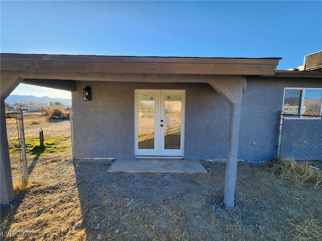 view of exterior entry with french doors and a mountain view