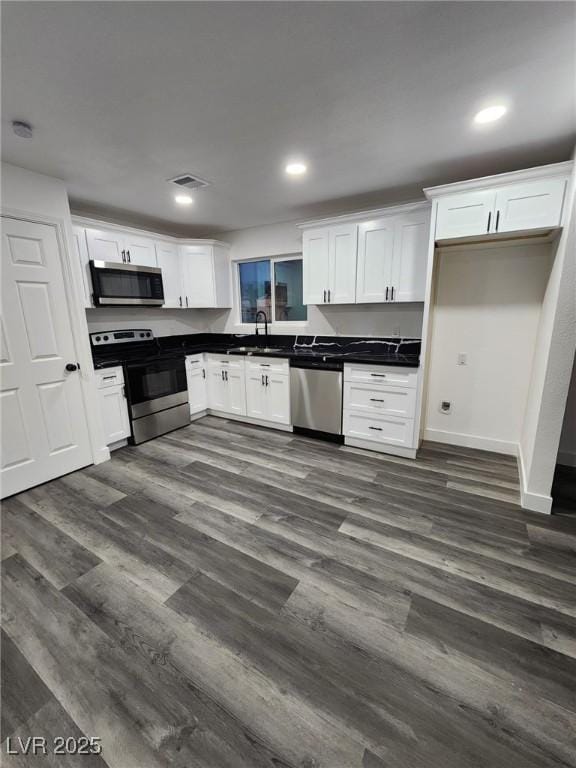 kitchen featuring sink, dark wood-type flooring, white cabinets, and stainless steel appliances