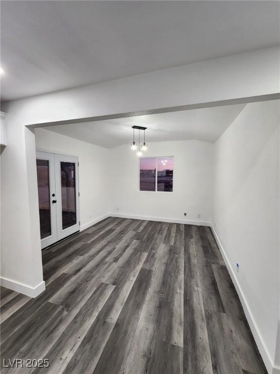 spare room with a chandelier, dark hardwood / wood-style flooring, and french doors