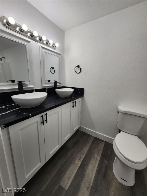 bathroom with toilet, vanity, and hardwood / wood-style flooring