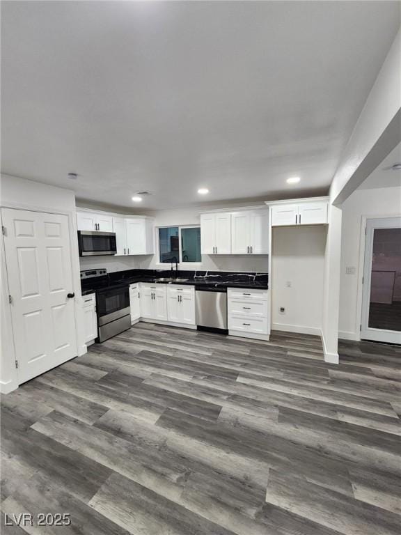 kitchen with sink, white cabinets, dark hardwood / wood-style floors, and stainless steel appliances