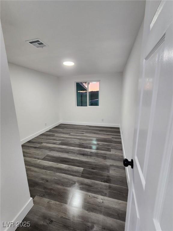 unfurnished room with dark wood-type flooring