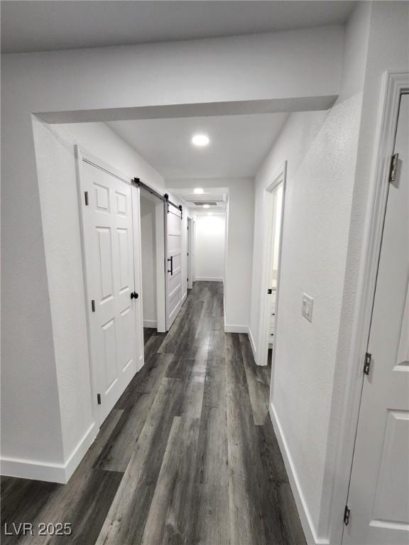 hall featuring a barn door and dark hardwood / wood-style floors