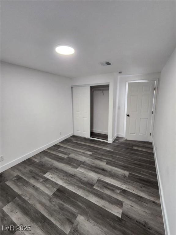 unfurnished bedroom with a closet and dark hardwood / wood-style flooring