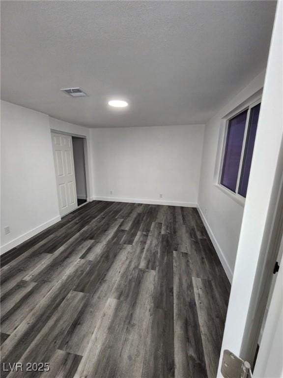 interior space featuring a textured ceiling and dark hardwood / wood-style flooring