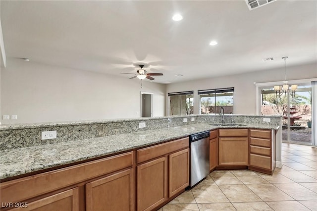 kitchen featuring light stone counters, visible vents, stainless steel dishwasher, brown cabinetry, and a sink