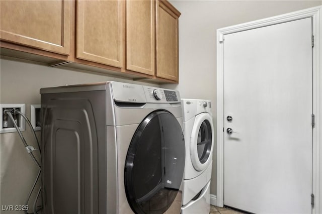 clothes washing area featuring separate washer and dryer and cabinet space