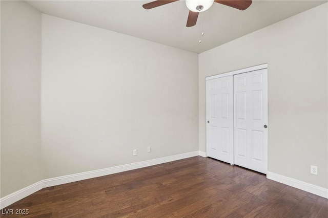 unfurnished bedroom with a closet, dark wood finished floors, a ceiling fan, and baseboards