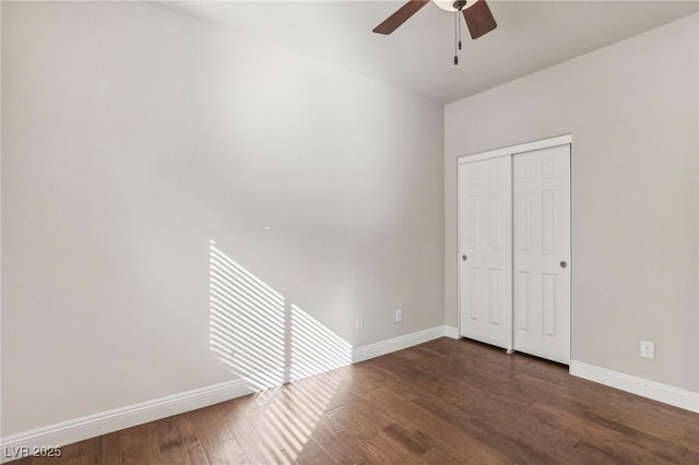 unfurnished bedroom featuring dark wood-style floors, ceiling fan, baseboards, and a closet