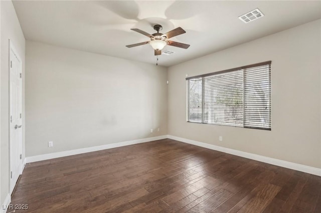 empty room featuring baseboards, dark wood finished floors, visible vents, and a ceiling fan