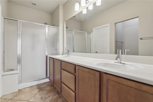 full bath with tile patterned flooring, a shower with shower door, a sink, and double vanity