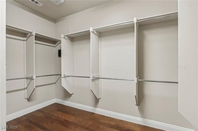 spacious closet featuring dark wood-type flooring and visible vents