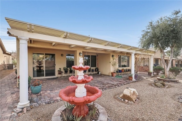 rear view of house with central AC, a patio area, and stucco siding