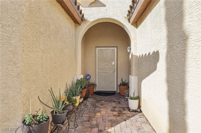 entrance to property featuring stucco siding