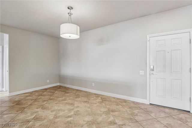 unfurnished room featuring light tile patterned flooring and baseboards