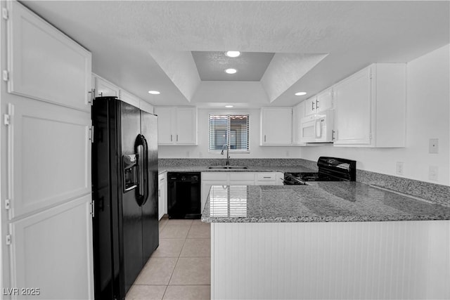 kitchen with black appliances, kitchen peninsula, sink, a tray ceiling, and white cabinets