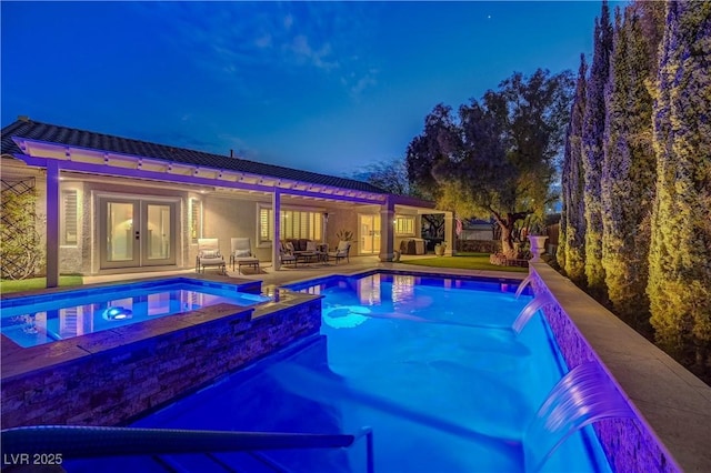 view of swimming pool with french doors, pool water feature, an in ground hot tub, and a patio area