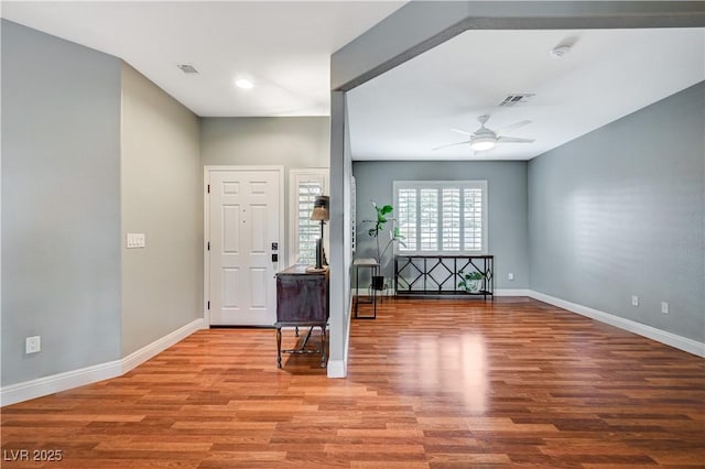 foyer entrance with ceiling fan and light wood-type flooring