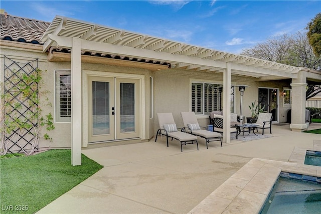 rear view of house with french doors, a pergola, and a patio