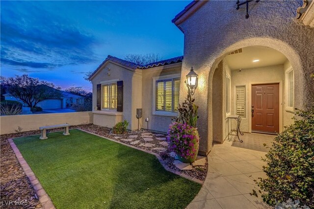 exterior entry at dusk with a yard