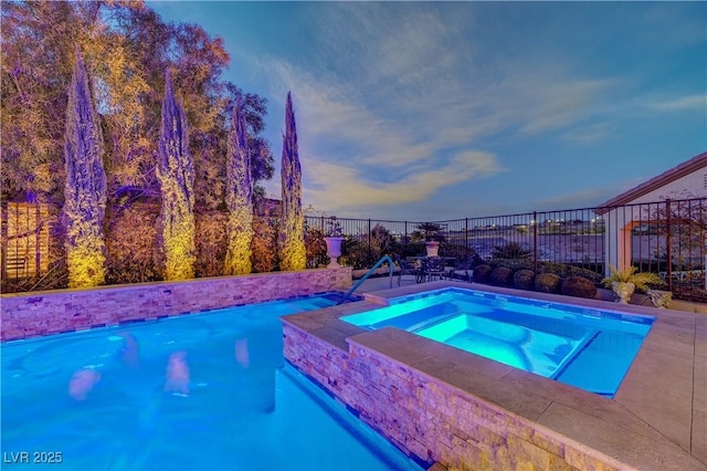 pool at dusk featuring an in ground hot tub