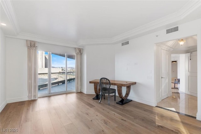 home office featuring baseboards, light wood-style flooring, visible vents, and crown molding