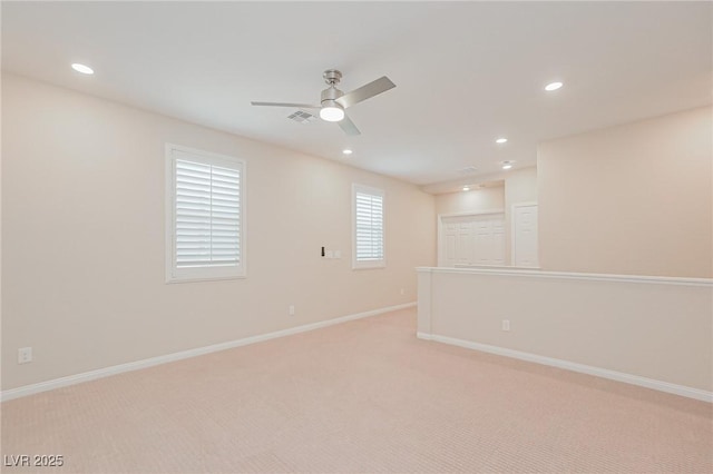 empty room featuring ceiling fan and light colored carpet