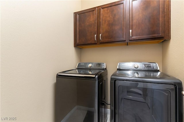 laundry room featuring cabinets and washing machine and clothes dryer