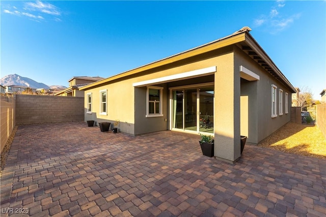 rear view of property with a mountain view and a patio