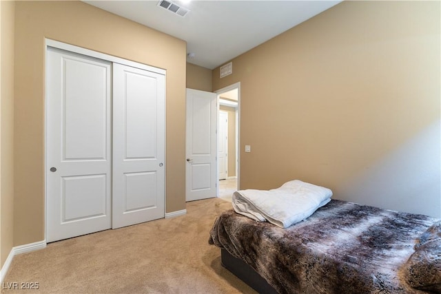 bedroom with a closet and light colored carpet