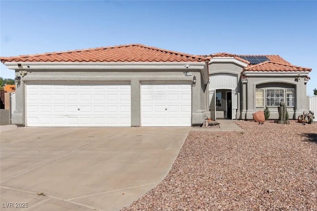 mediterranean / spanish-style home featuring solar panels and a garage