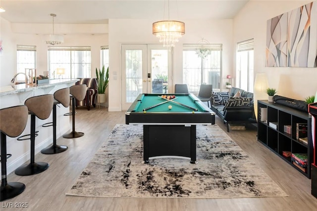 recreation room featuring sink, an inviting chandelier, light wood-type flooring, french doors, and pool table