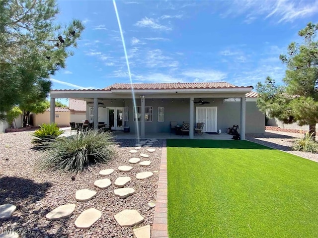 back of house featuring ceiling fan, a lawn, and a patio