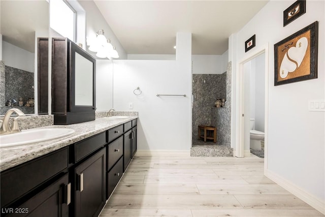 bathroom with vanity, toilet, and a tile shower