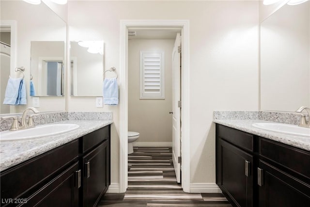 bathroom featuring hardwood / wood-style flooring, vanity, and toilet