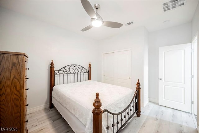 bedroom with light hardwood / wood-style flooring, a closet, and ceiling fan