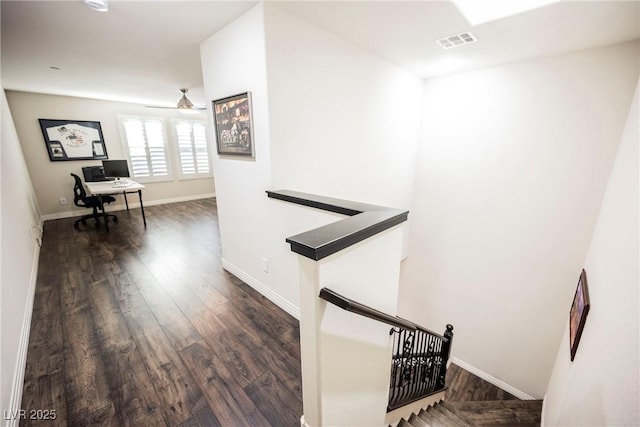 staircase with hardwood / wood-style flooring and ceiling fan