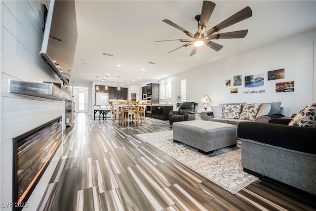 living room with ceiling fan and wood-type flooring