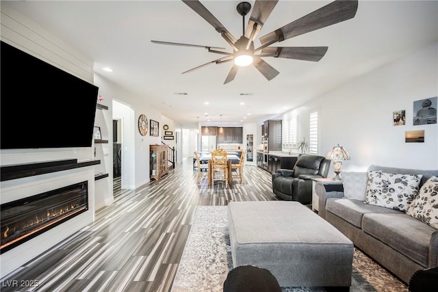 living room featuring ceiling fan and wood-type flooring