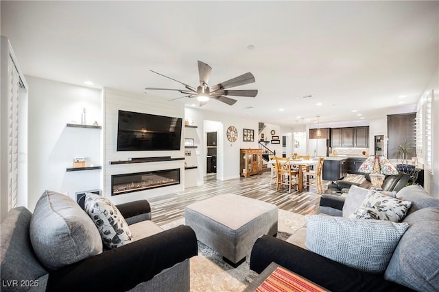 living room with ceiling fan and light hardwood / wood-style floors