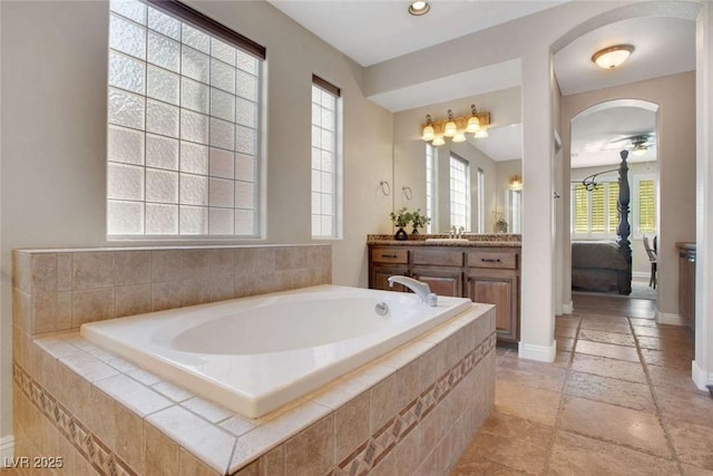 bathroom with tiled bath and vanity