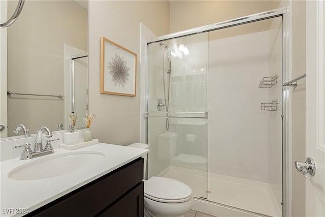 bathroom with a shower with shower door, toilet, and vanity