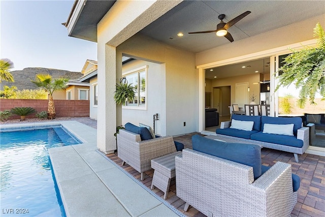 view of patio featuring ceiling fan, an outdoor living space, and a fenced in pool