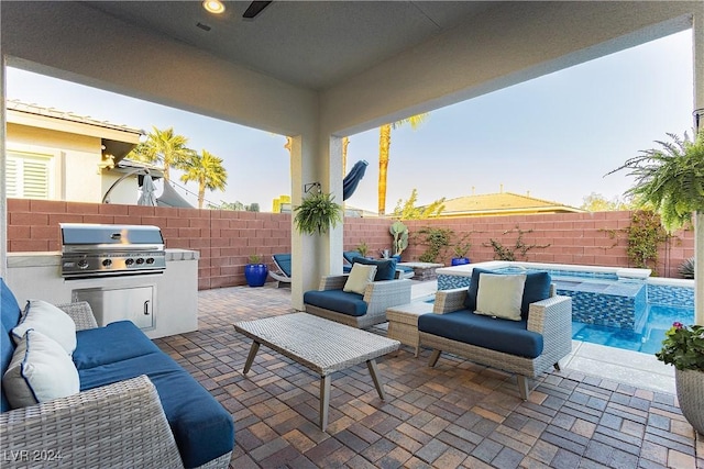 view of patio with a pool with hot tub, outdoor lounge area, pool water feature, grilling area, and an outdoor kitchen