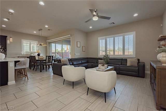 living room featuring ceiling fan and a wealth of natural light