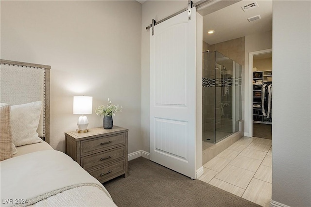 bedroom with a barn door, a closet, and a spacious closet