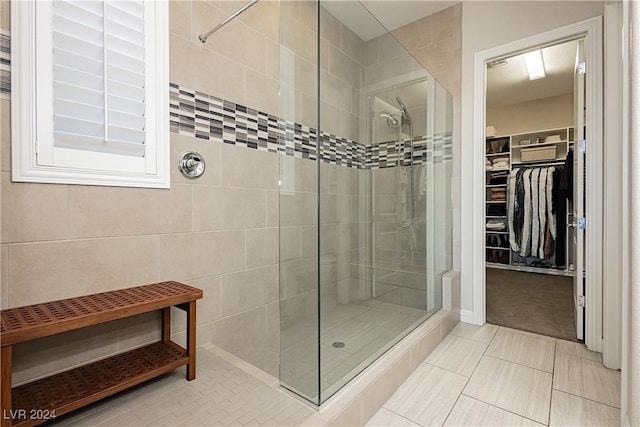 bathroom featuring tile patterned flooring and a tile shower